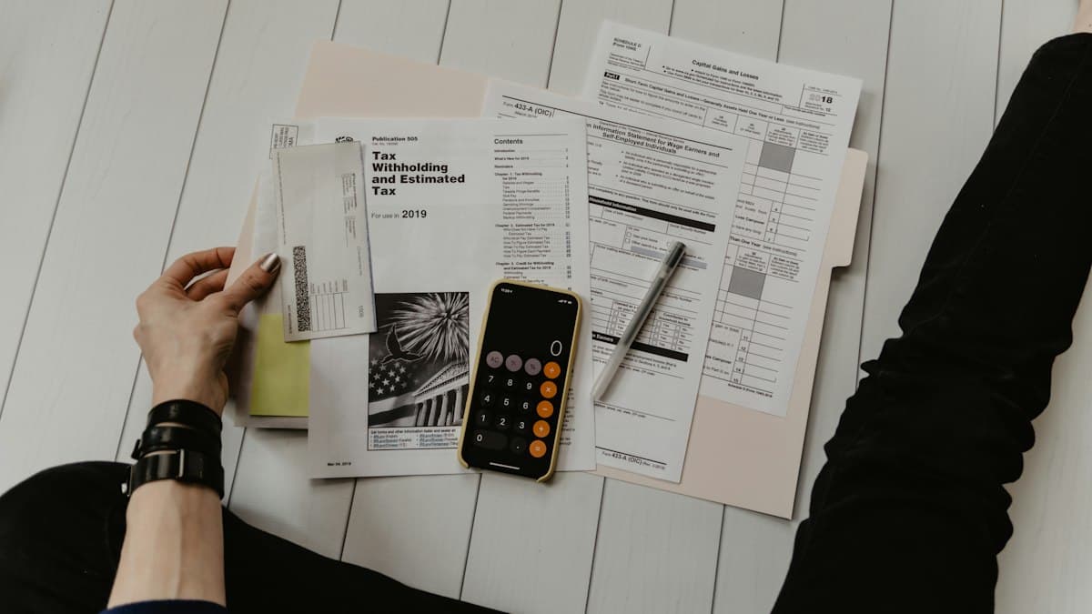 Hands reviewing a paper document next to a calculator