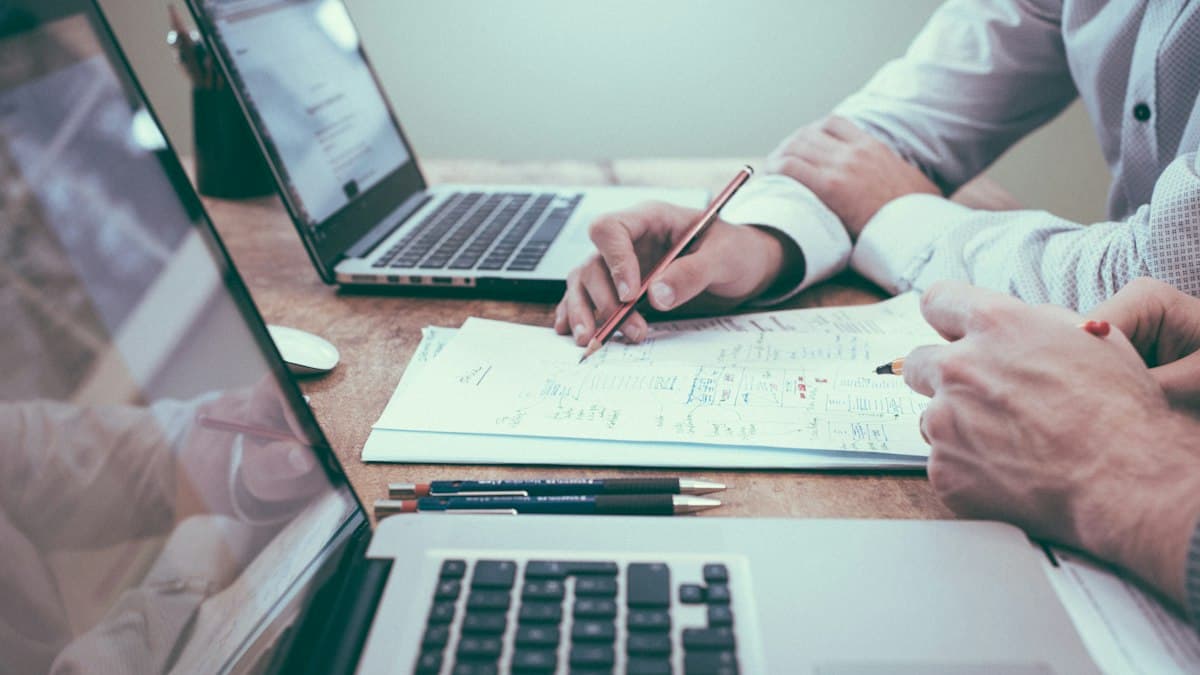 A person working on paperwork at a laptop