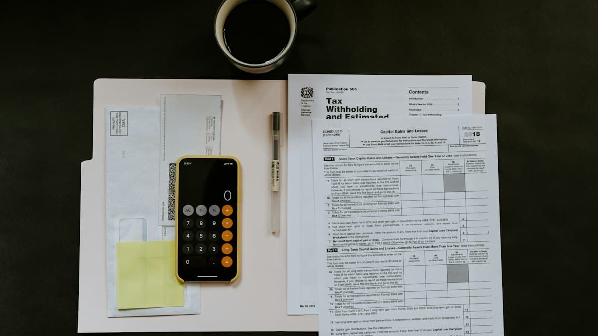 A tax certificate on a folder beside a pen and phone